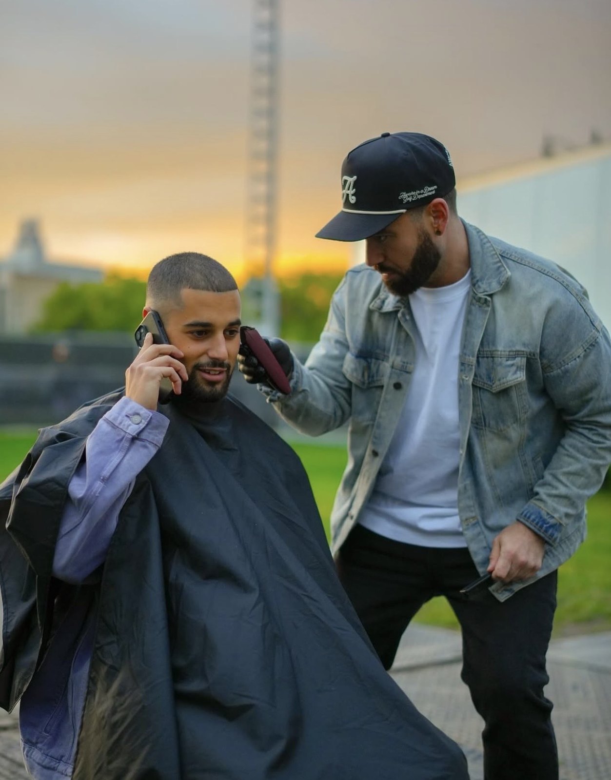Behind-the-scenes moment between two performers near an outdoor stage