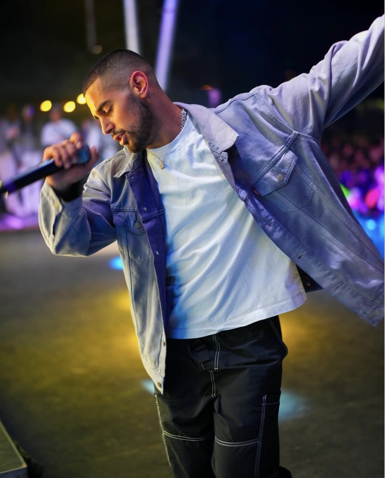 Vocalist leaning toward the crowd during an outdoor live performance