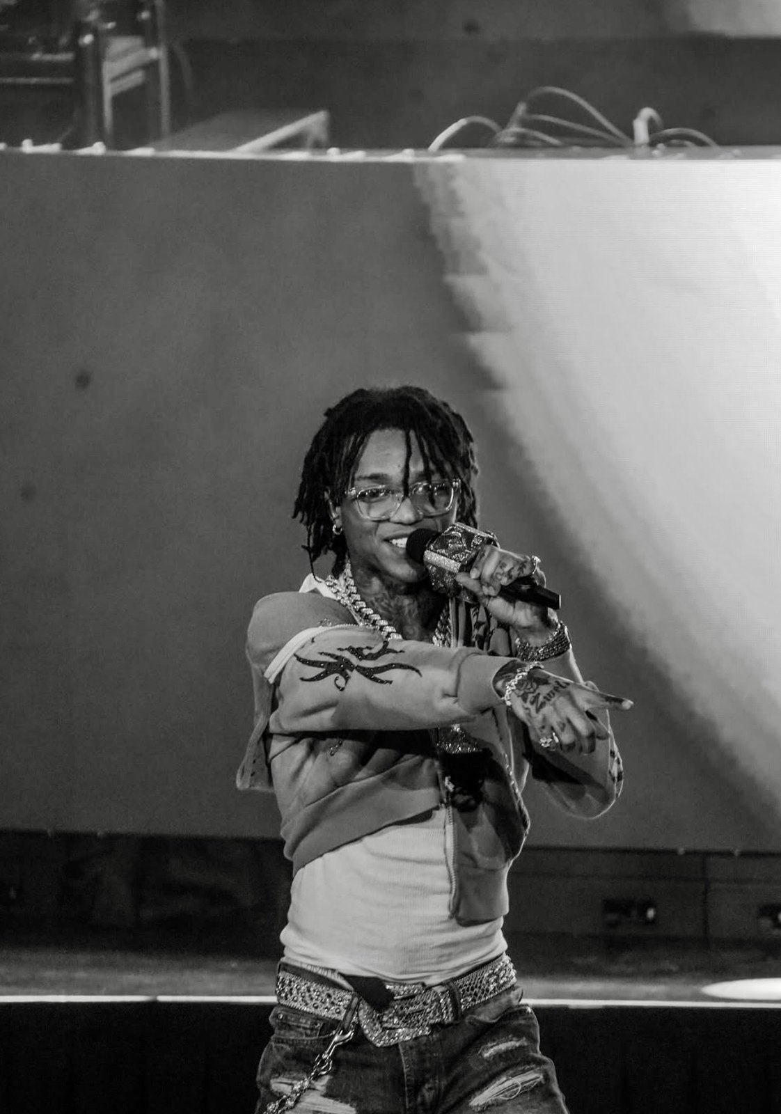Live vocalist gesturing toward the audience in black and white