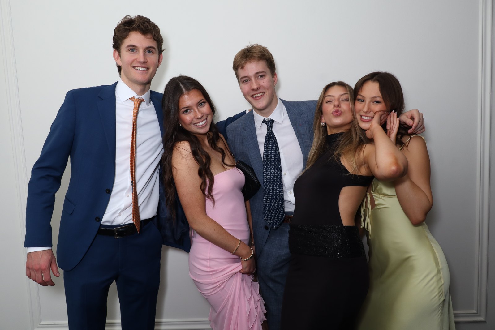 Group of five guests posing at the photo booth