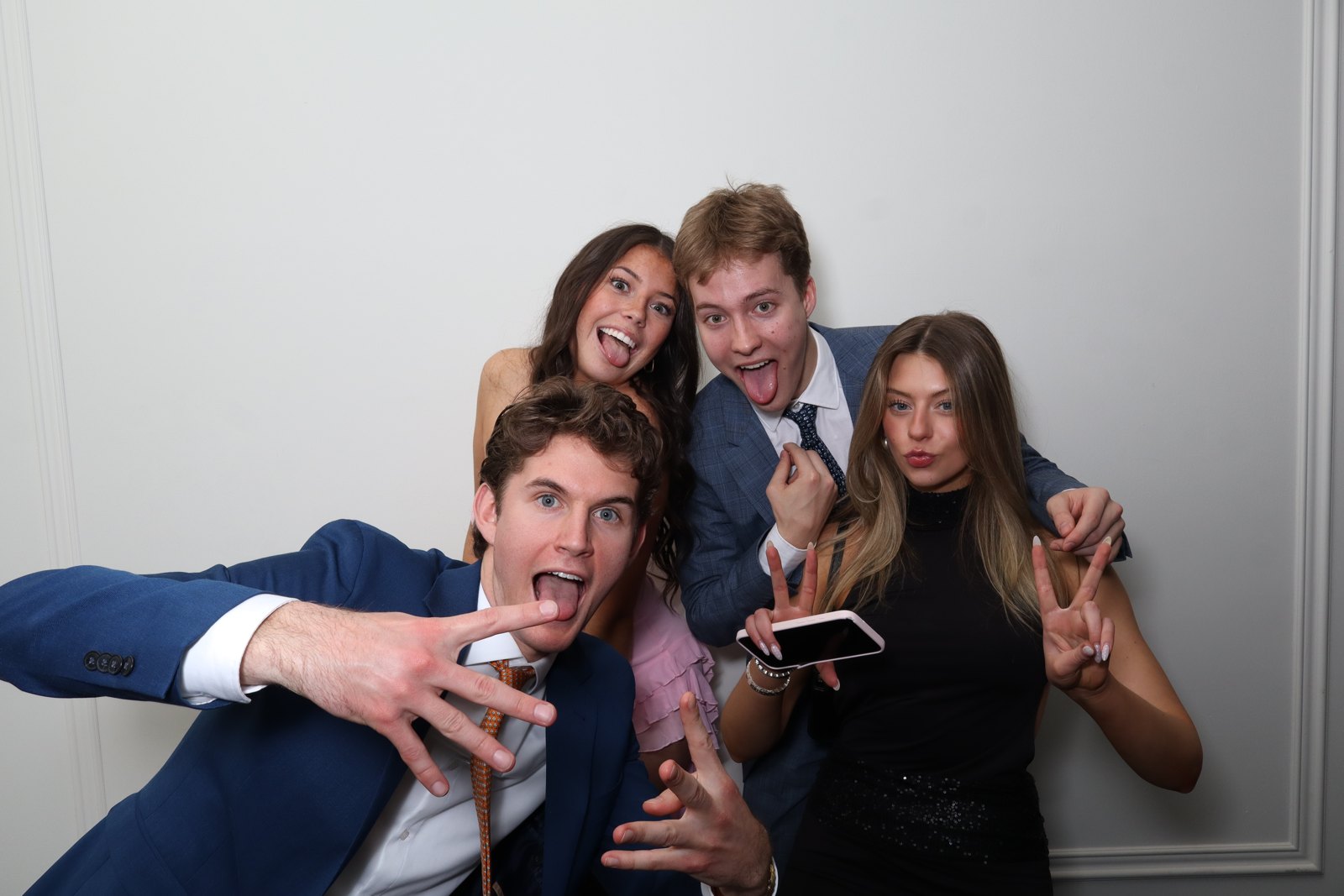 Friends leaning into the photo booth camera