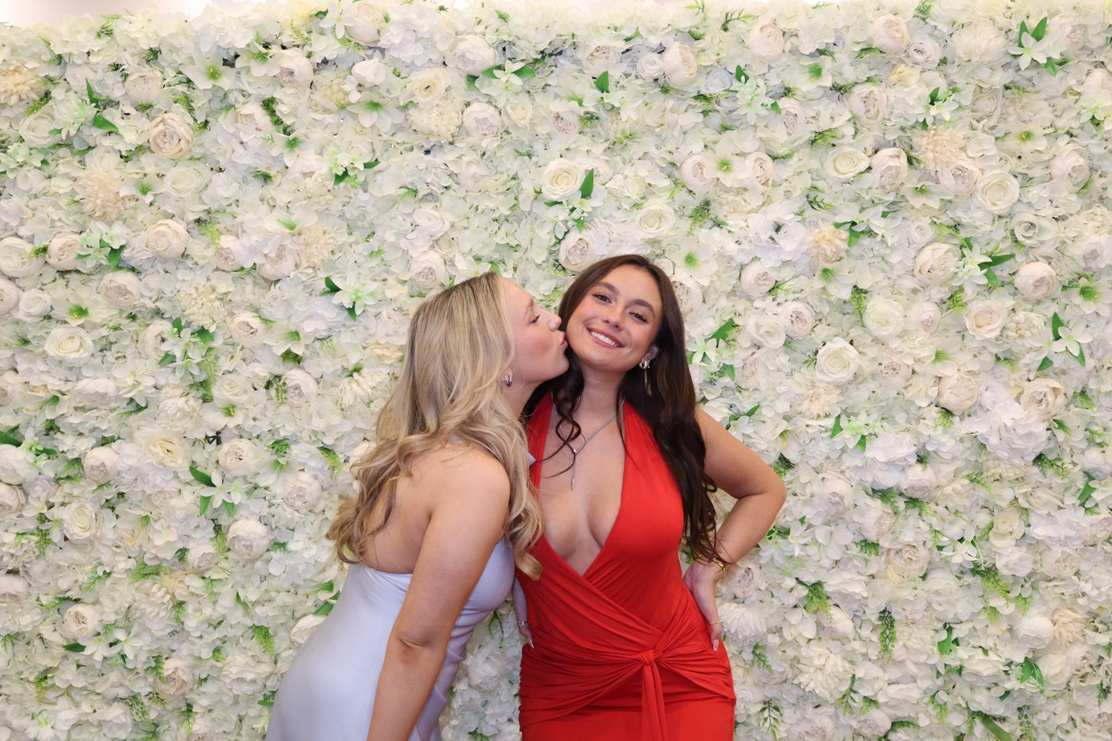 Two guests leaning together for a playful booth portrait