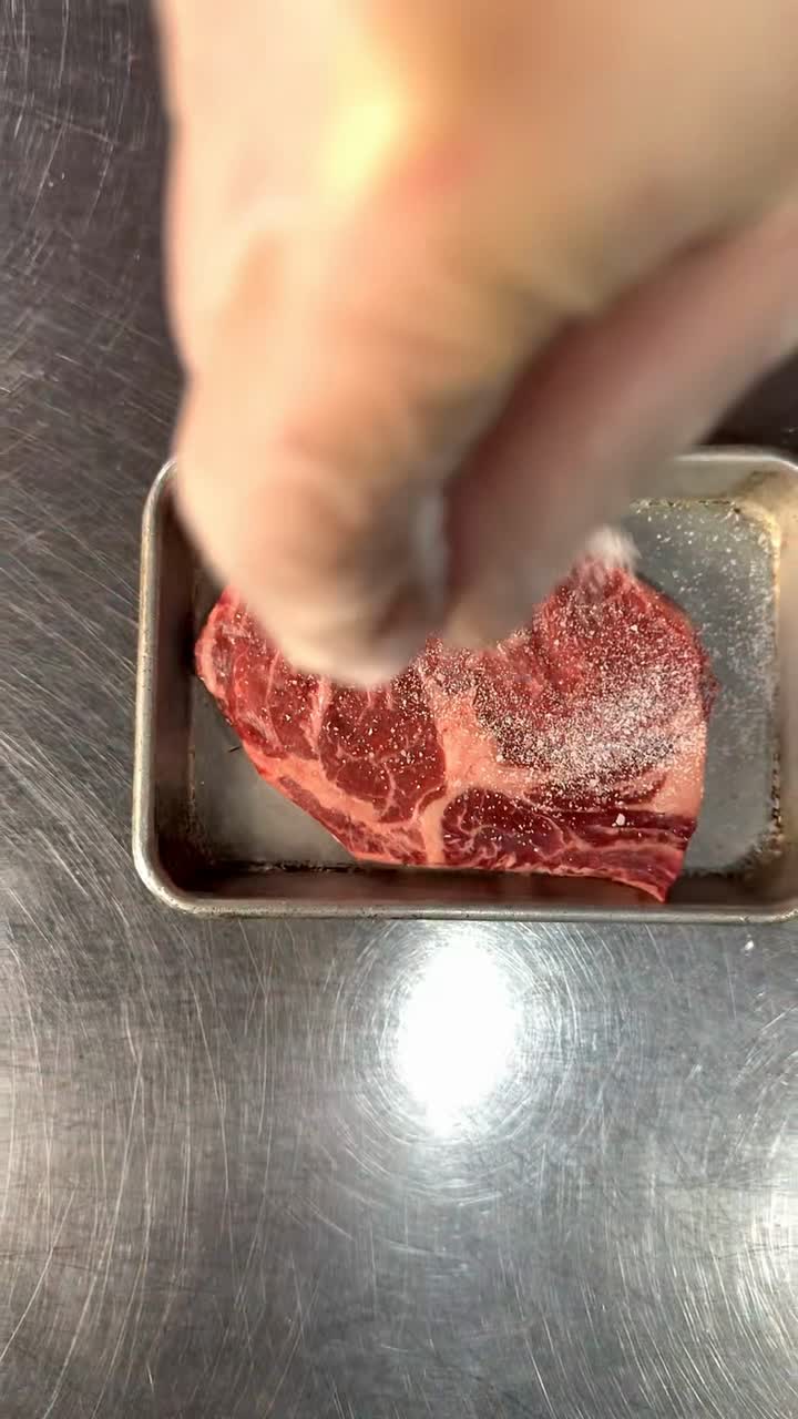 Close-up of a steak being seasoned for a restaurant video